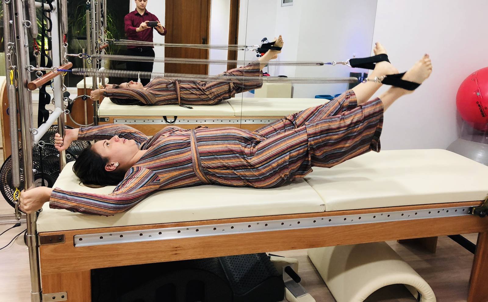 Paciente em exercício no reformer com acompanhamento da equipe do Instituto Thé